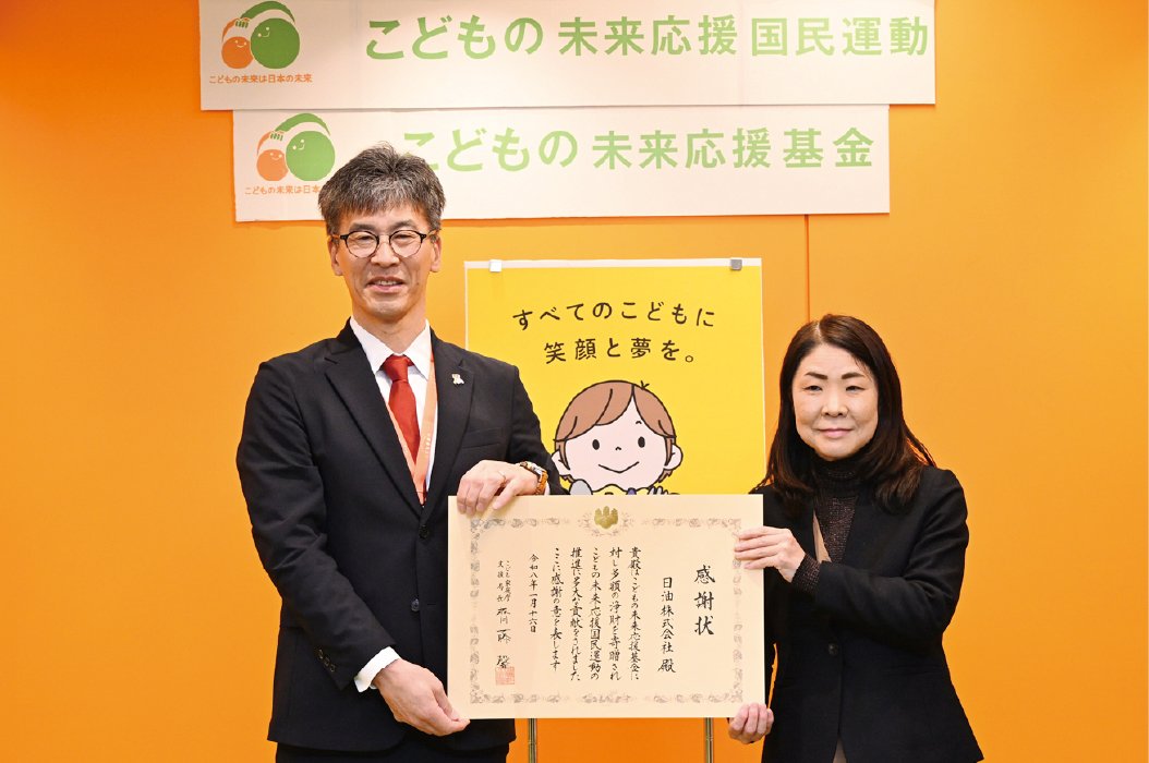 This is a photo of two people showing a single letter of appreciation.