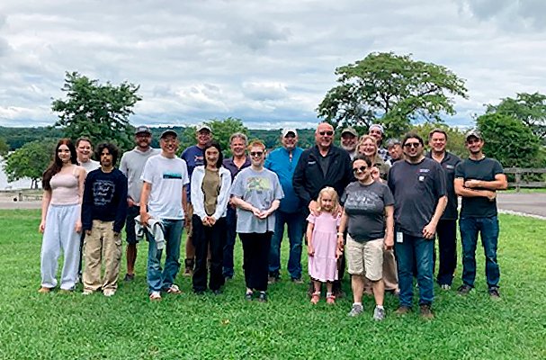 This is a group photo of twelve men and women gathered in a friendly atmosphere.