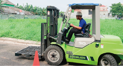 This is a photo of an employee operating a forklift outdoors.