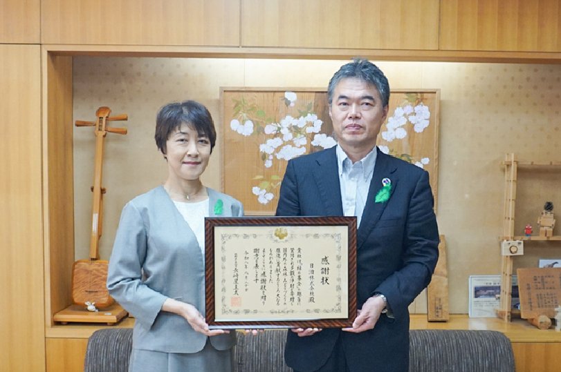 This is a photo of two people showing a single letter of appreciation.