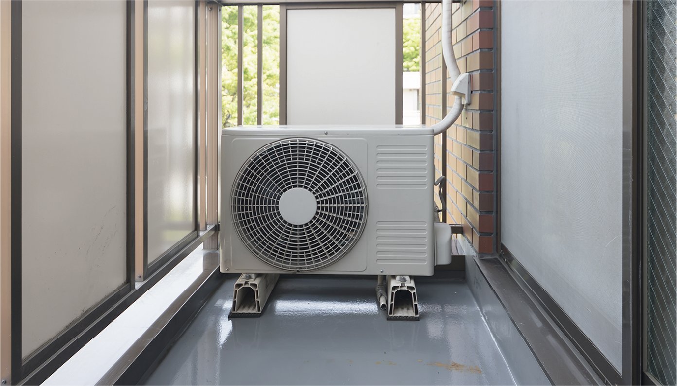 The outdoor unit for the air conditioner is placed in the corner of the balcony.