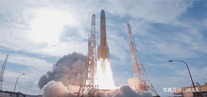大きなロケットが発射台から打ち上げられた直後で、大きな炎と煙を吹き出しながら空に飛び立とうとしています。